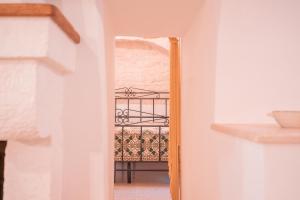 a hallway with a mirror and a chair in a room at Villa Trullo Vecchia Aia in Alberobello