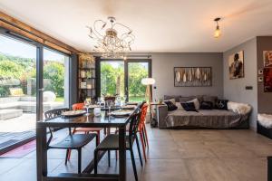a dining room with a table and chairs and a couch at Maison neuve proche lac d'Annecy in Saint-Jorioz