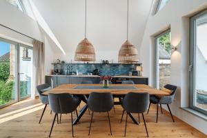 a dining room with a wooden table and chairs at Das Alte Pfarrhaus - Scheune in Gleisweiler