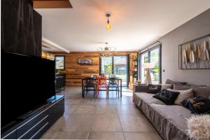 a living room with a couch and a tv at Maison neuve proche lac d'Annecy in Saint-Jorioz
