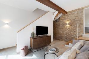 a living room with a couch and a tv at Das Alte Pfarrhaus - Scheune in Gleisweiler