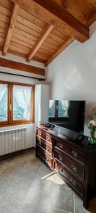 a living room with a television on a wooden dresser at Come Una Volta Apricale antica dimora ligure - Parcheggio a pochi metri in Apricale