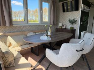 a living room with a table and chairs and a couch at De Ree Tiny House Tussen de Dijken in Driewegen +19 photos
