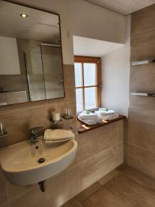 a bathroom with a sink and a mirror at Ferienwohnung Polsing 19 in Palling