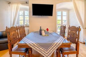 a dining room with a table and a tv on the wall at Ferienwohnung Schatztruhe in Maring-Noviand