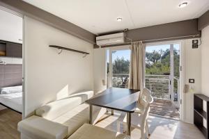 a living room with a table and a couch at Mobile Home Next 229 in Pietra Ligure