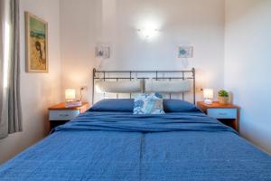 a bedroom with a blue bed with two lamps at Casa Nuages in Badesi