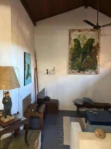 a living room with a painting of birds on the wall at Refúgio da Vila in Ilhabela