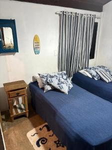 a bedroom with two beds and a mirror at Refúgio da Vila in Ilhabela