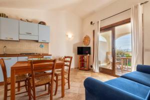 a kitchen and living room with a table and chairs at Casa Nuages in Badesi