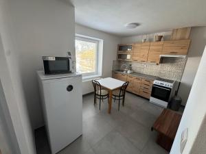 a small kitchen with a table and a small refrigerator at Tatrabyt in Bánovce nad Bebravou