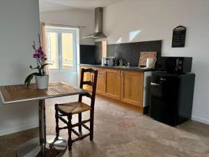 a kitchen with a table and a black refrigerator at VILLA.H GARDEN in Cramant