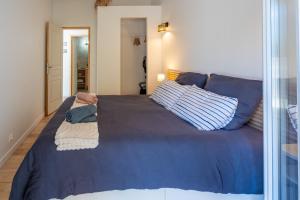 a bedroom with a blue bed with blue sheets and pillows at Rose Antique in Valréas