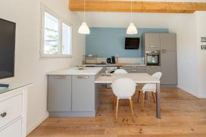 a kitchen with white cabinets and a table and chairs at Rose Antique in Valréas