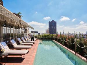 a row of lounge chairs next to a swimming pool on a building at Hotel El Palace Barcelona in Barcelona