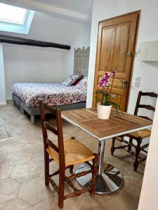 a room with a table and a bedroom with a bed at VILLA.H GARDEN in Cramant