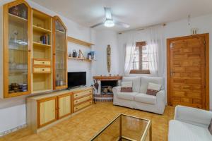 a living room with a white couch and a television at Playa Arenales del Sol in Arenales del Sol
