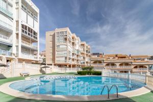 a large swimming pool in front of some buildings at Playa Arenales del Sol in Arenales del Sol