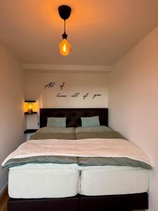 a bedroom with a large bed with words on the wall at Aarebar Rooms in Solothurn