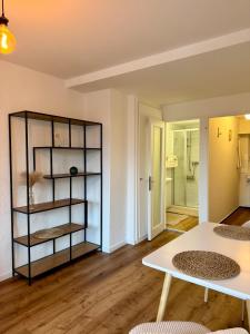 a living room with a table and a shelf at Aarebar Rooms in Solothurn
