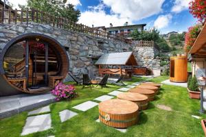 a garden with a stone wall and a table and benches at Affittacamere De Charme Jour Et Nuit in Torgnon