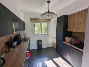 a kitchen with black and white cabinets and a window at U Flenu sea view in San-Martino-di-Lota
