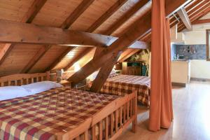 two beds in a attic room with wooden ceilings at L'orée du bois in Yenne +26 photos