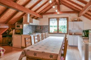 a kitchen with a large table in a room at L'orée du bois in Yenne