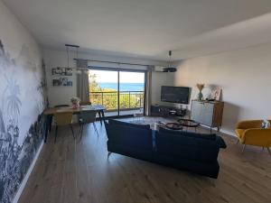 a living room with a couch and a table at U Flenu sea view in San-Martino-di-Lota