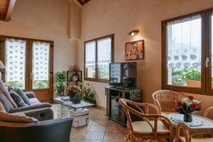 a living room with a couch and a tv at L'orée du bois in Yenne