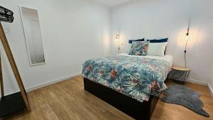 a small bedroom with a bed with a colorful blanket at A m a r - 450m from the beach in São Roque