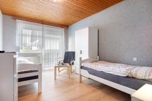 a bedroom with a bed and a chair and a window at Monteurwohnung in Schwanewede