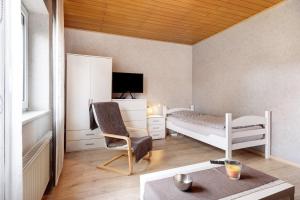 a room with a bedroom with a bed and a chair at Monteurwohnung in Schwanewede