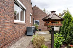 a bird house in a garden next to a brick building at Monteurwohnung in Schwanewede