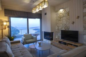 a living room with a couch and a tv at Modern Country Villa in Lefkada