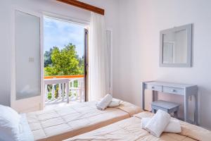 a bedroom with two beds and a window with a view at Maltas studios in Corfu