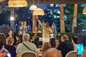 a man standing on a stage with a group of people at Royal Garden Beach Hotel in Konaklı +98 photos