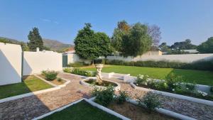 a garden with a fountain in the middle of a yard at De Kothuize 12 in Graaff-Reinet