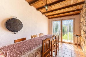 a dining room with a table and chairs and a window at La Nave de Gredos in Burgohondo