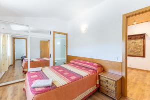 a bedroom with two beds and a mirror at La Nave de Gredos in Burgohondo +34 photos
