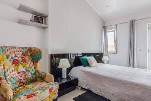 a bedroom with a bed and a couch and a chair at Vista Das Estrelas M4 - Terceira in Praia da Vitória