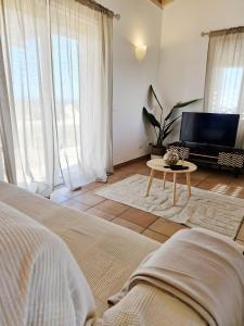 a bedroom with a bed and a tv and a table at Paraiso da Serva - Courela da Serva in Odemira