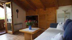 a living room with a couch and a table with flowers at Ferienwohnung Kramerblick in Grainau