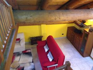 Challand Saint VictorにあるMaison des Challantの赤いソファと黄色の壁が特徴のリビングルーム