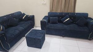 a living room with two blue couches and a table at عمارة دار الضيافة in Medina