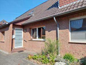 a brick house with a white door and windows at Ferienwohnung Sonnenschein in Tülau
