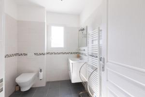 a white bathroom with a toilet and a sink at Residence Cismonte in Morosaglia +13 photos