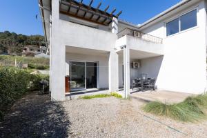 a white house with a patio and a table at Residence Cismonte in Morosaglia