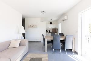 a white living room with a table and chairs at Residence Cismonte in Morosaglia