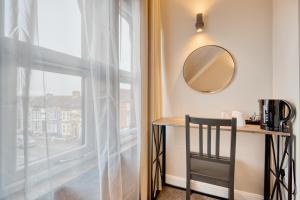 a mirror and a table in a room with a window at The Stuart Hotel in Liverpool